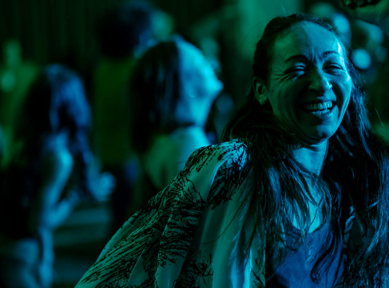 A dancer smiling in the blue light