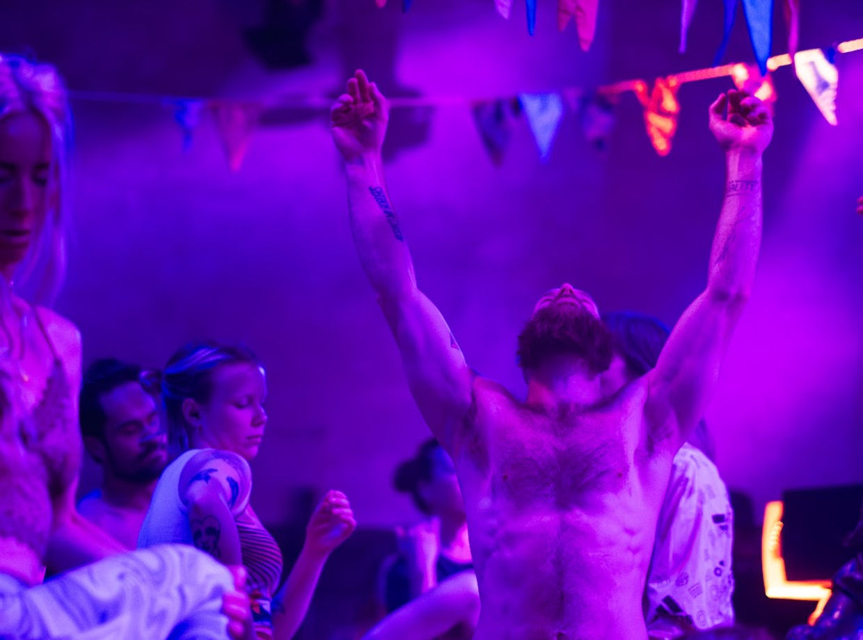 Arms up in purple light