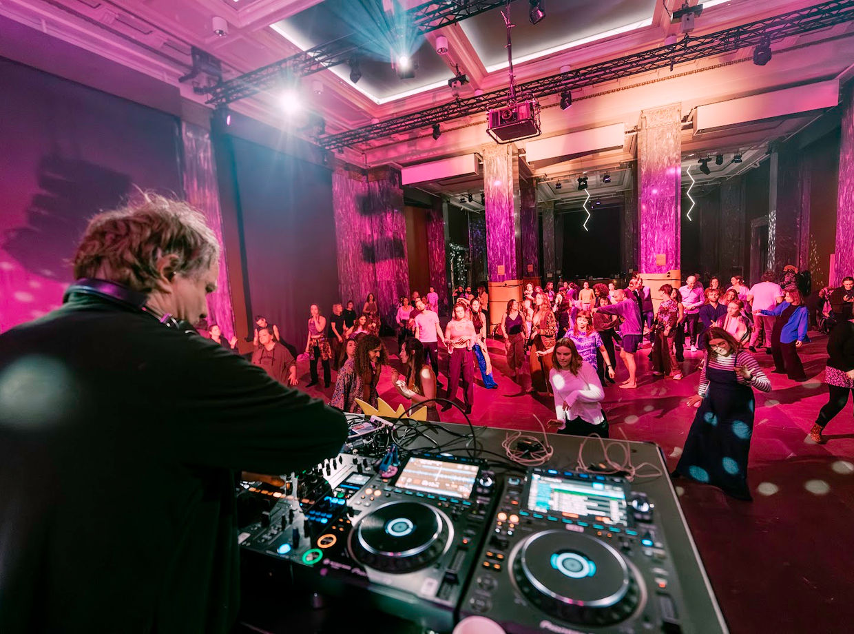 The DJ at the decks facing the crowd