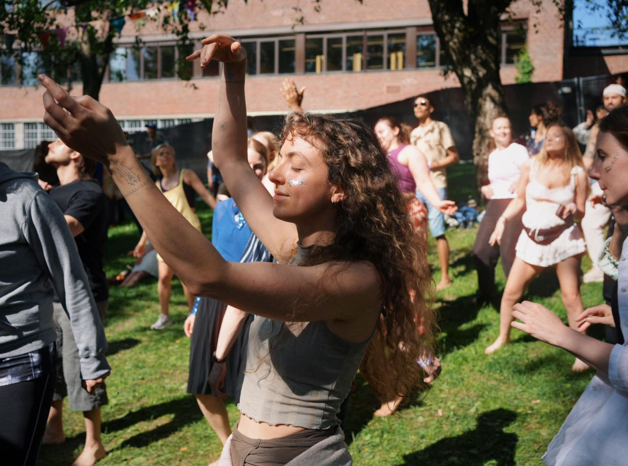A dancer with her arms raised to the sky