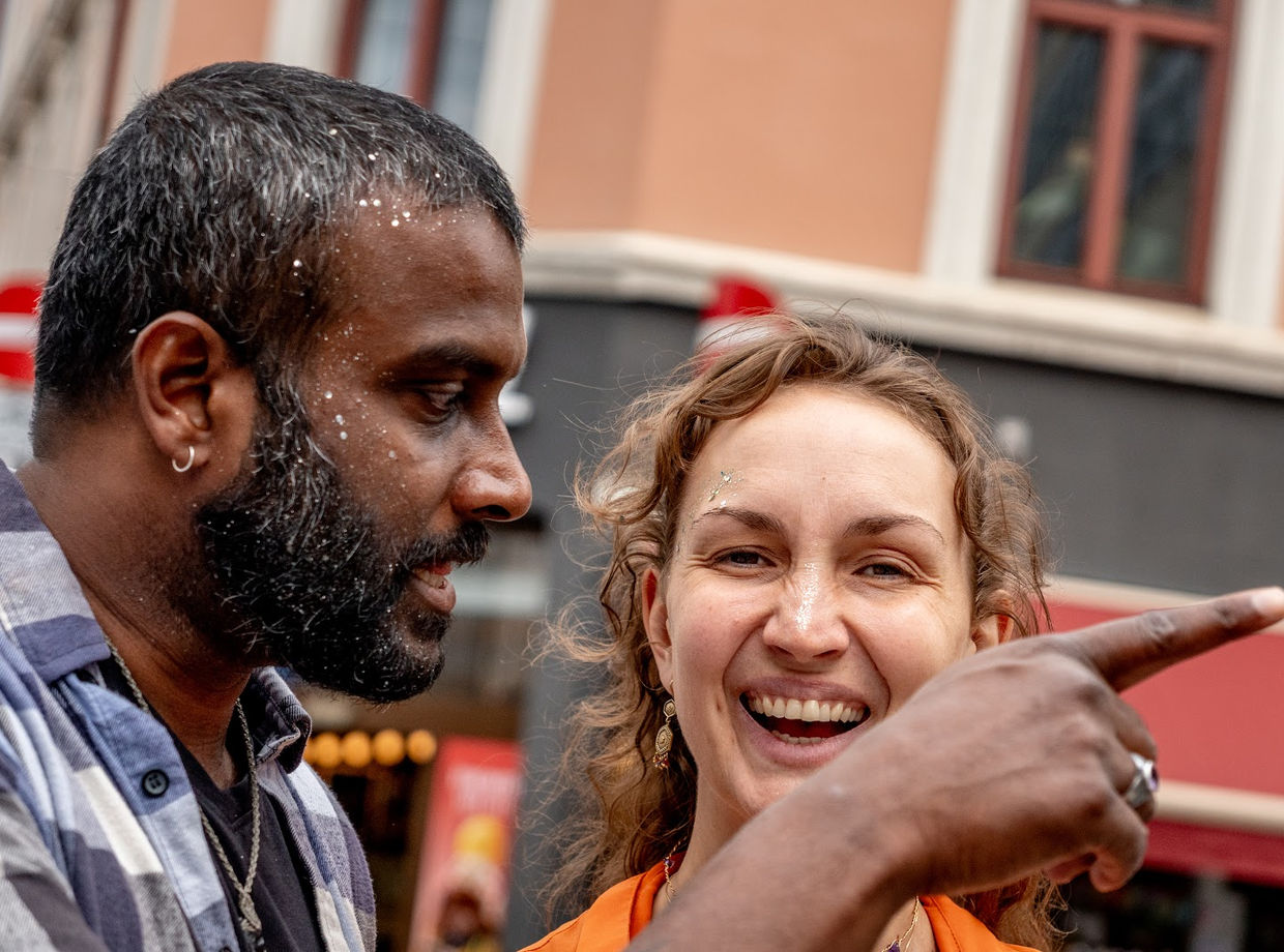 Two dancers laughing together in the street