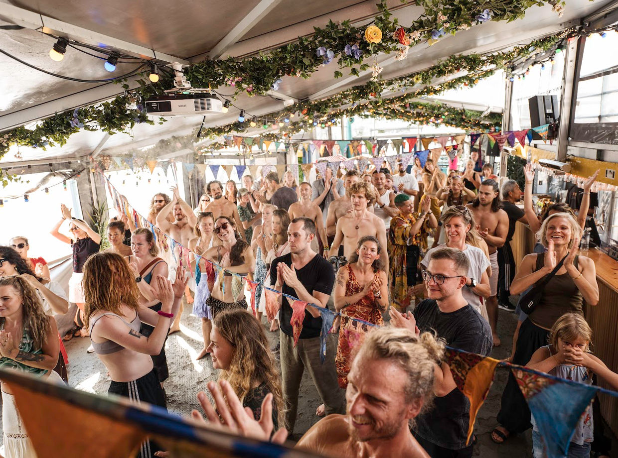 A crowd dancing on the boat in the sun