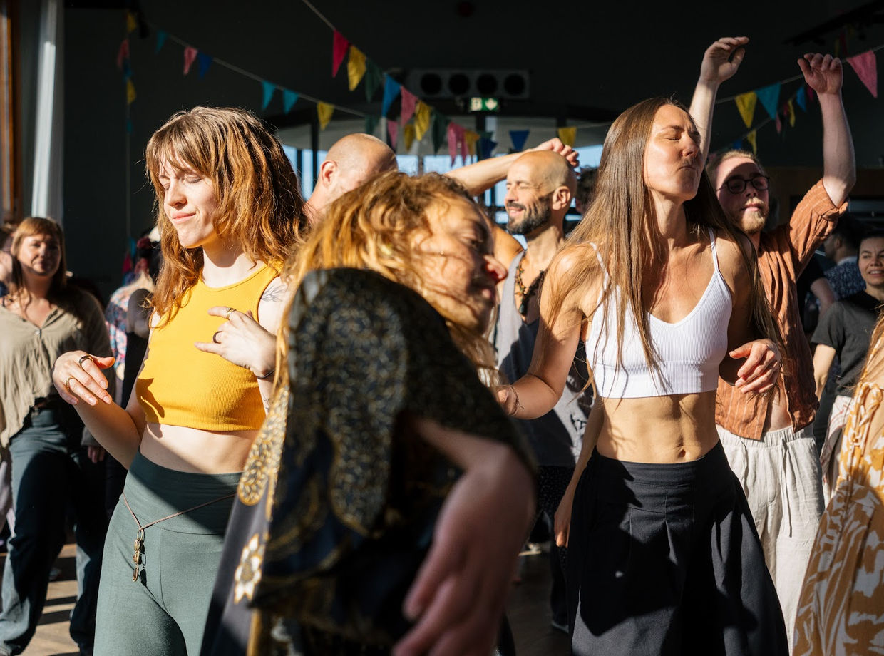 A crowd dancing hard in the morning light