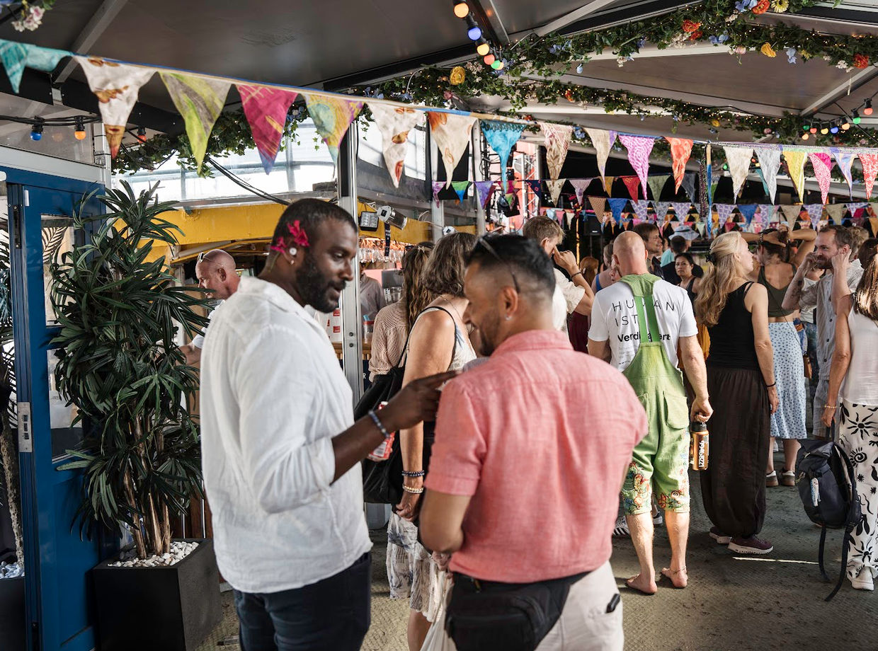 Guests mingling under the bunting on board