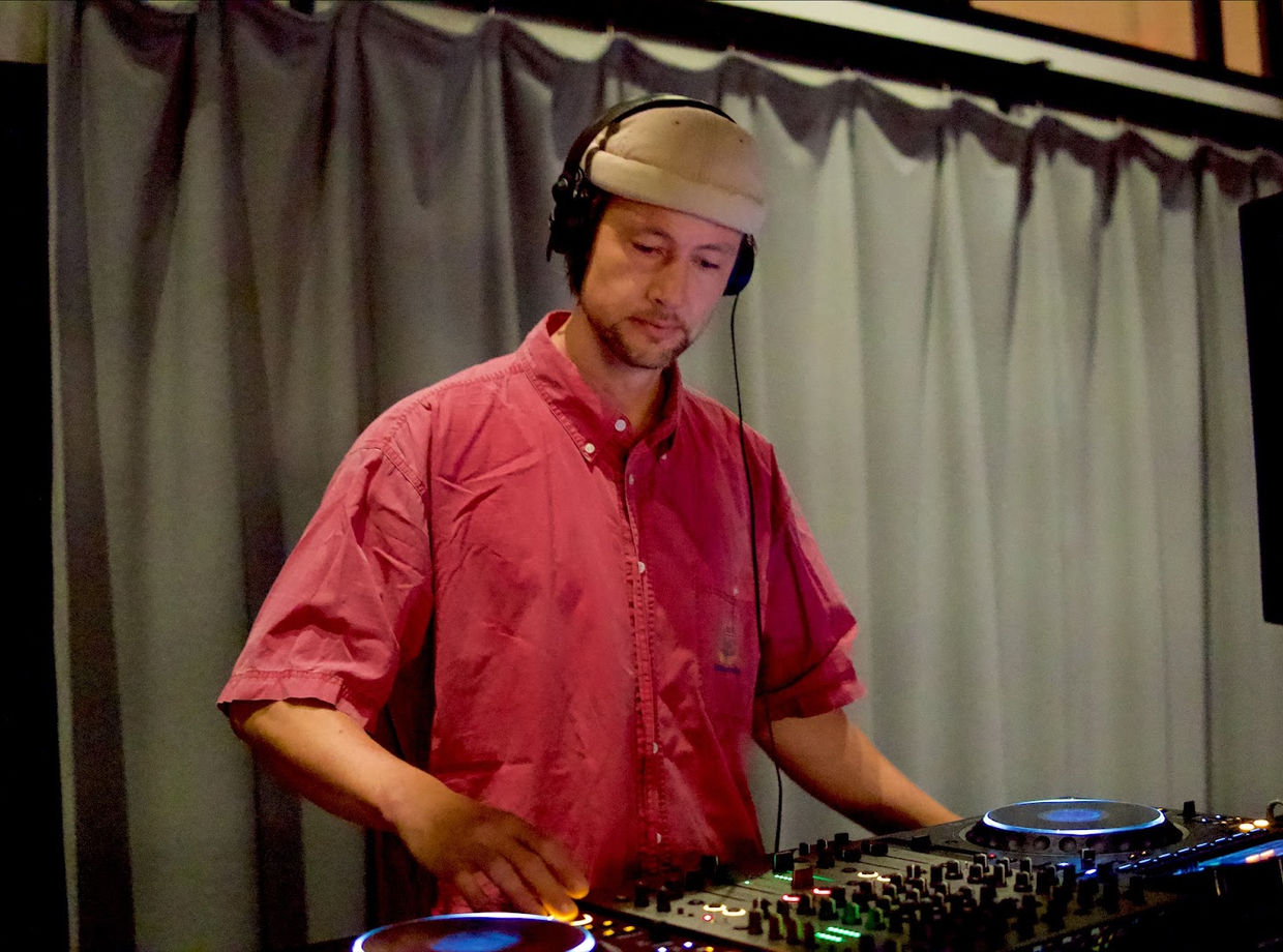 Schei at the decks with headphones on