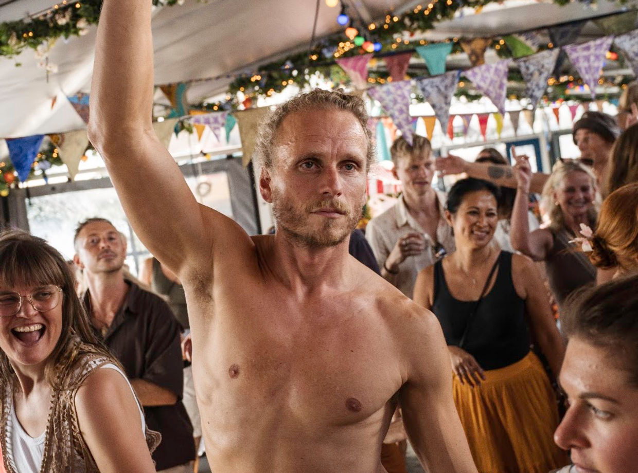 A dancer with his arm raised on deck